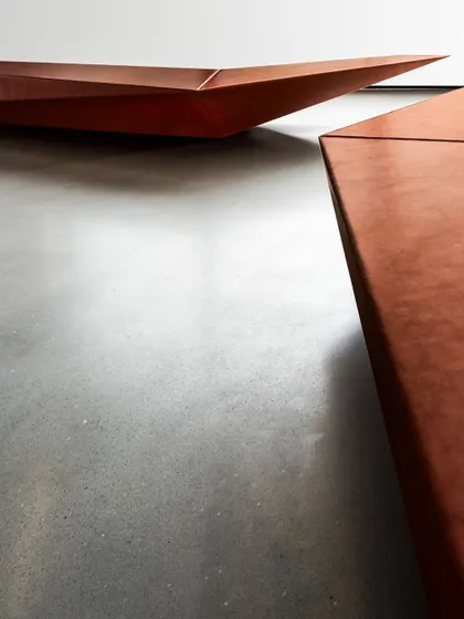 A detailed shot of the custom-designed benches in the Parinee lobby, highlighting their sharp, faceted form and textured finish.