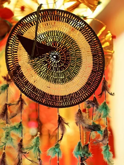 A detailed shot of a woven dreamcatcher, part of the bohemian and rustic decor elements used in a Haldi ceremony.