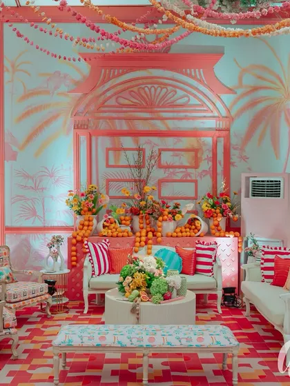 This lounge area showcases our use of custom-painted backdrops to define a space. The palm tree mural, paired with patterned furniture and piles of fresh oranges, creates a relaxed yet sophisticated tropical Italian vibe.