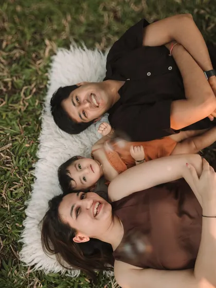 A fun, aerial shot of the family lying on a blanket and looking up at the camera with big smiles.