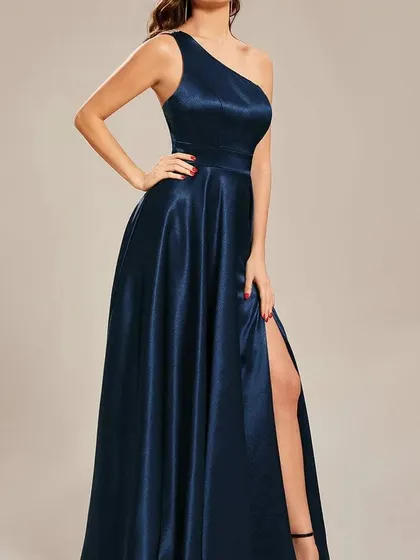 Another angle of the one-shoulder navy satin gown, highlighting the way the fabric catches the light and the flattering cut of the silhouette.