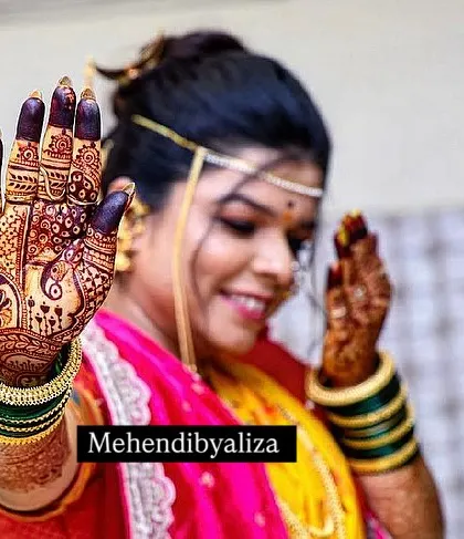 A happy bride showing off her dark stained henna. A deep color like this is the ultimate goal for any bridal mehendi.