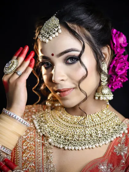A Bengali-inspired bridal look with traditional alta on the hands and a classic red bindi. Our courses cover a wide range of regional bridal styles.