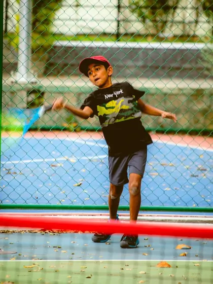 Another shot of a junior player in action, showing the dynamic movement we encourage. Our red and orange ball programs are not just about hitting, but also about learning to move like a tennis player.