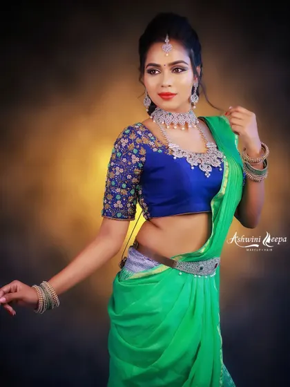 A vibrant green saree paired with a contrasting royal blue embroidered blouse. This look is perfect for guests who want to make a statement at a wedding.