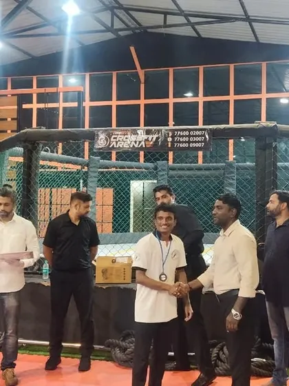 Coach Vinod receiving his medal at an MMA club event. His consistent performance and willingness to step into the cage sets a powerful example for all our aspiring fighters.
