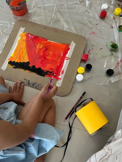 A child focused on painting a sunset. We introduce basic concepts like blending and perspective in an accessible way, allowing children to create beautiful scenes while learning new techniques.
