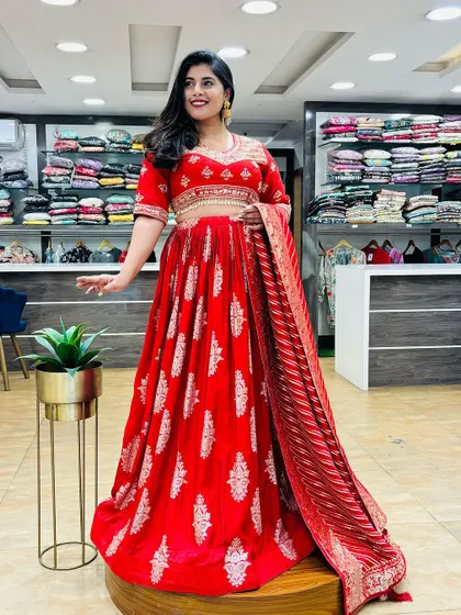 A stunning red Anarkali-style lehenga, perfect for making a statement. The intricate silver work and flowing silhouette make it a royal choice for any grand occasion.