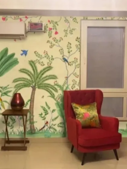 A bright and cheerful tropical wallpaper with colorful birds and palm trees, perfectly complementing the bold red armchairs.