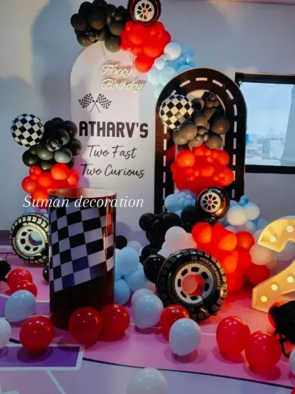 The full view of the 'Two Fast Two Curious' racing theme, showing the large marquee number '2' and the checkered plinth.