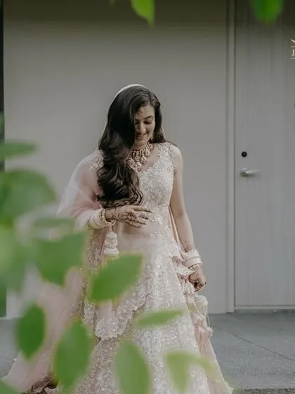A candid moment of the bride, looking radiant in her Polki necklace set before the ceremony begins.
