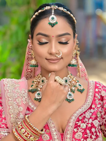 A close-up shot showing the beautiful winged eyeliner and soft glam makeup that complements the heavy bridal jewellery without competing with it.
