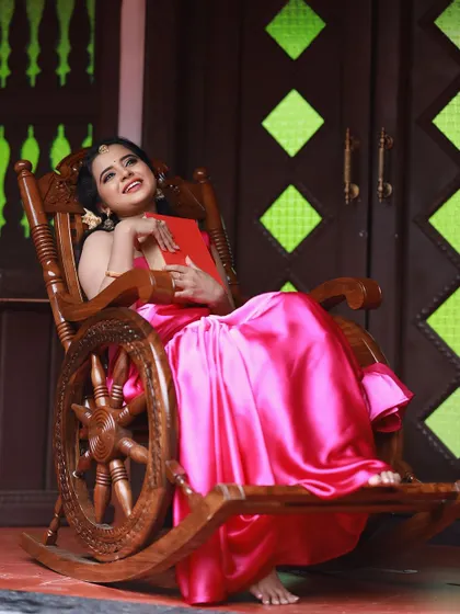A relaxed and graceful pose in our pink satin saree, showing its versatility and comfort.