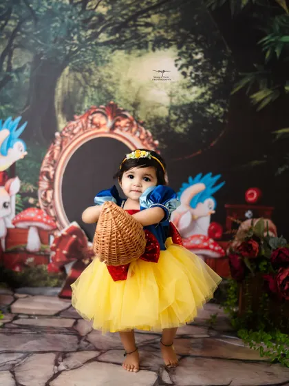 This little princess is ready for a walk through the woods with her basket. The Snow White theme is a timeless choice for a magical birthday or milestone shoot.