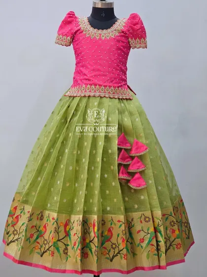 A similar design with a pink blouse and a light green skirt. The skirt features a lovely woven Paithani border with parrot motifs.