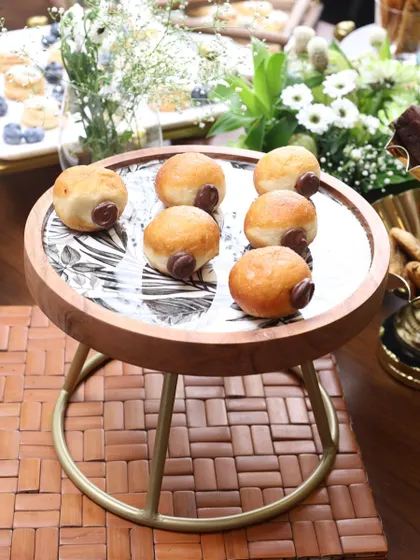 The Moon Ray stand with a monochrome leaf print, serving delicious doughnuts. Its elevated design and stylish pattern make it a versatile addition to your hosting collection.