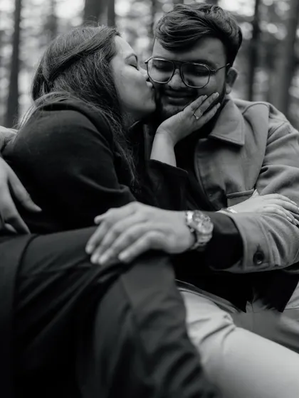 A sweet kiss on the cheek. This black and white close-up is full of warmth and genuine affection, a perfect candid moment.