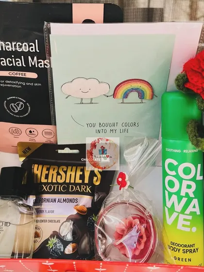A Valentine's Day gift box for him, including a charcoal facial mask, dark chocolate, perfume, body spray, and a cute card that says "You bought colors into my life."