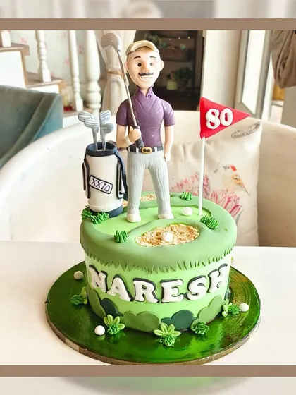 A perfect cake for a golf lover's 80th birthday, featuring a fondant figure on a green with a golf bag and flag.