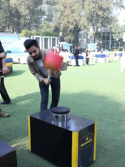 A guest in mid-swing at the hammer game, showing the dynamic action this rental brings to an event.