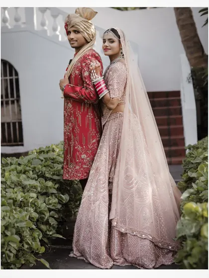 A classic wedding portrait of the couple at Prainha Resort, Goa, with lush greenery and classic architecture.