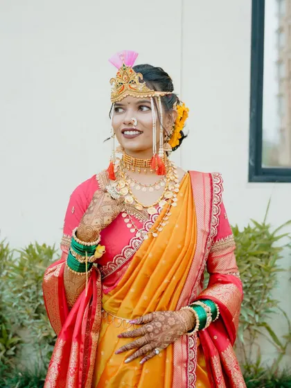 A full length shot of the bride in her yellow and pink Nauvari saree, showcasing the perfect drape.