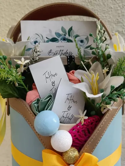 A close-up of the birthday basket, showing the 'Happy Birthday' card and the 'To Have & To Hold' tags on the scrunchies.