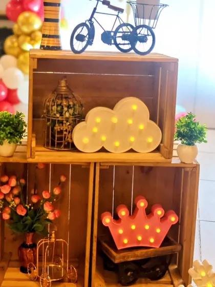A collection of rustic and charming props, including wooden crates and light-up marquee shapes like a crown and cloud.