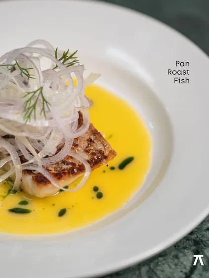 A close-up of the Pan Roast Fish, showcasing the crispy skin and delicate fennel salad from the Praça Prazeres pop-up.