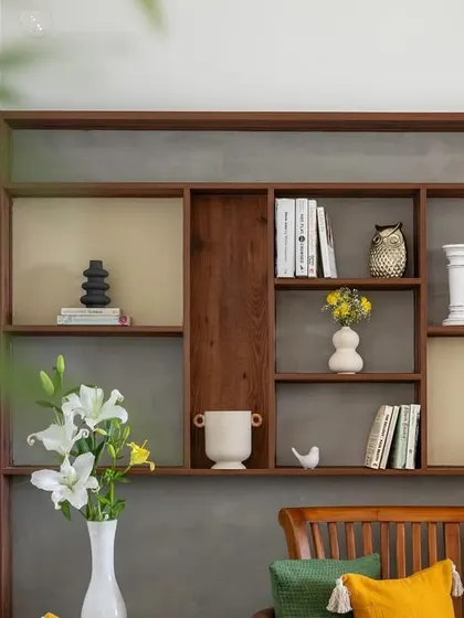 In a compact living area, we carved niches behind the sofa to create this bookshelf and curio unit, adding storage and a beautiful focal point.