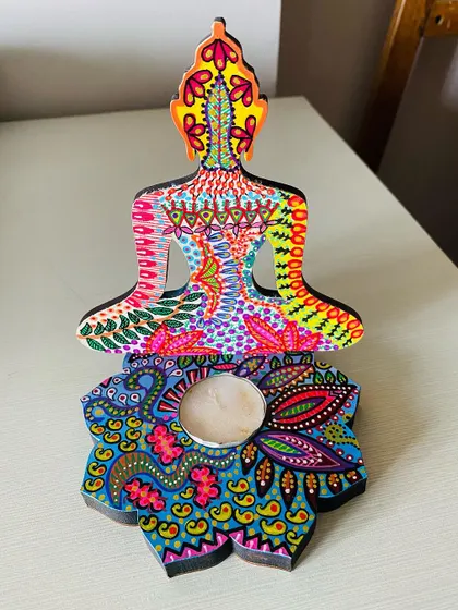 A front view of one of my hand-painted Buddha candle holders. The psychedelic patterns on the body and the lotus base are full of vibrant detail.
