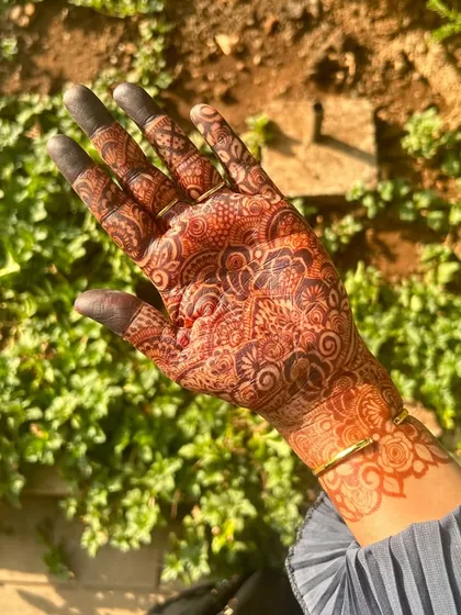 A close-up of a full-palm bridal henna stain, achieved with my organic cones. The design is packed with detail, including delicate netting, floral motifs, and shaded elements, all showing up clearly thanks to the quality of the paste.