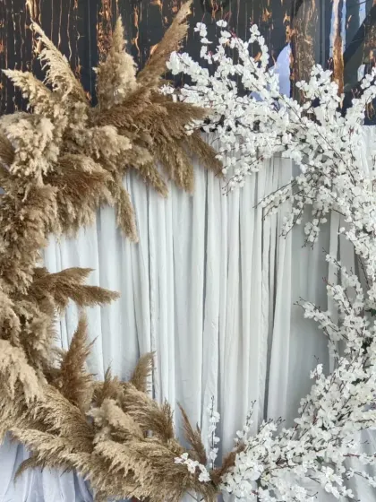 A unique and artistic backdrop combining two different textures. One half of the ring is decorated with earthy pampas grass, while the other half features delicate white cherry blossoms.