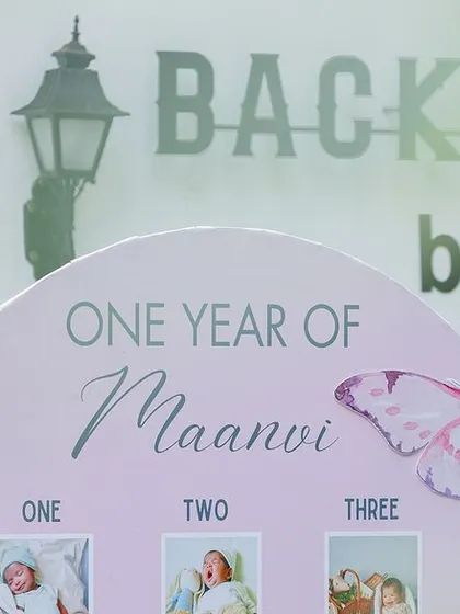 A personalized milestone board celebrating "One Year of Maanvi." This is a beautiful way to share the baby's journey with guests and serves as a cherished keepsake after the party.