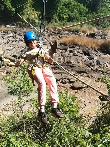 A young participant hangs out on the ropes, enjoying the adventure at our Barapole camp.