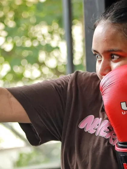 A female boxer throwing a punch, showing the form and focus we develop.