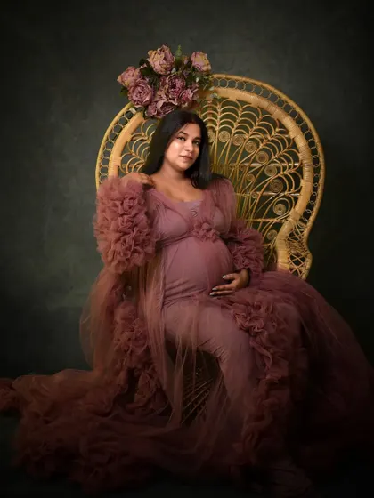 Seated on my studio's peacock chair, this portrait has a touch of boho elegance. The floral crown complements the ruffled gown perfectly.