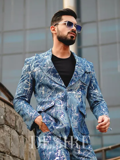 A full-body shot that showcases the bold individuality of the blue splatter-print suit. This is power dressing for the man who makes his own rules.