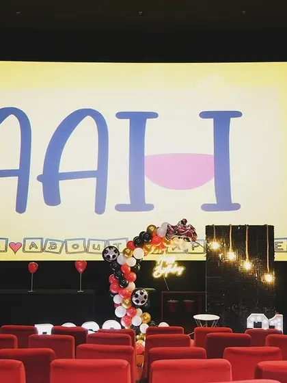 The empty theatre, beautifully decorated and ready for the surprise. The big screen is the perfect canvas for a grand, personal message.