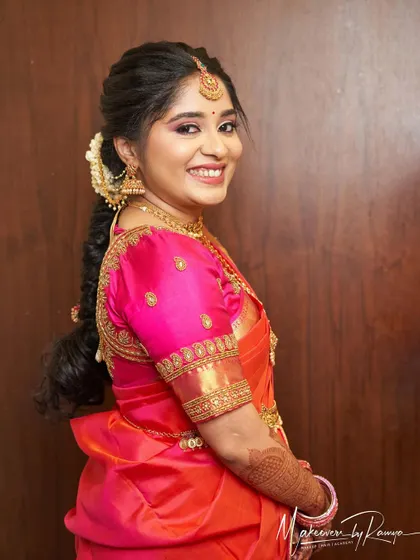 A side profile showcasing Vidhatri's bridal hairstyle, a classic braid adorned with flowers.