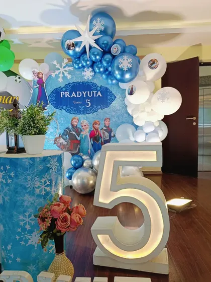 A detailed look at the Frozen-themed side, with a blue and silver balloon arrangement, snowflake accents, and a large marquee number '5'.