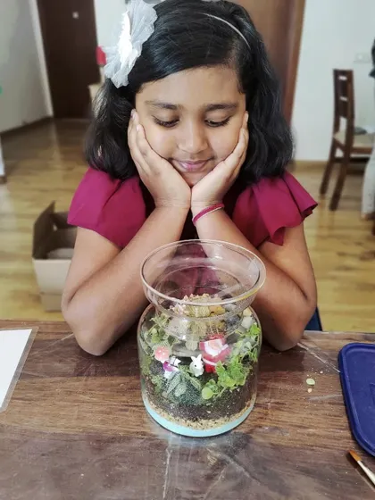 A young girl admiring her finished closed terrarium. These workshops are a perfect choice for parents looking for a fun and engaging activity to do with their kids.