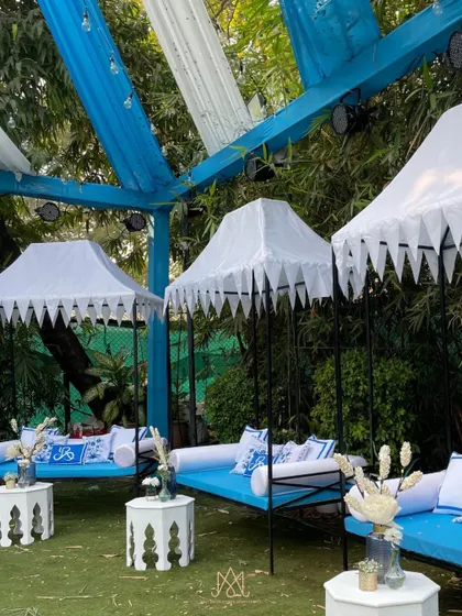 Elegant canopied daybeds with custom blue and white cushions provide a comfortable and stylish lounge option for guests.