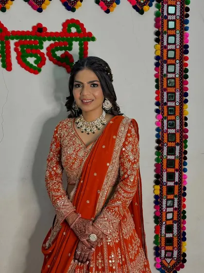 A full view of her engagement look against a traditional backdrop. The colours of her outfit and the decor create a vibrant, festive feel.