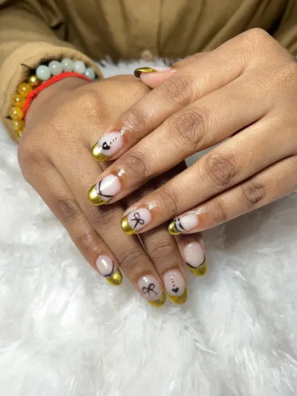 I love this chrome French nail art. I used a gold chrome powder for the tips and added some cute, hand-painted black bows and hearts for a playful and stylish design.