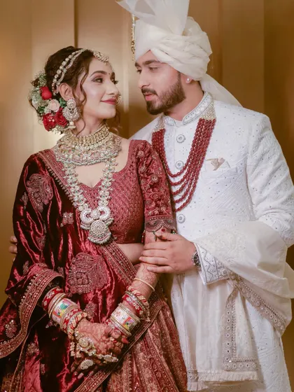 A stylish portrait of the couple, highlighting their stunning velvet and white wedding outfits and the love they share.