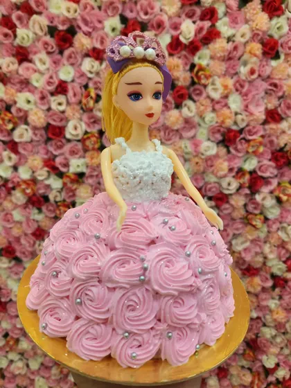 Another lovely doll cake design, this one with a pink rosette-piped dress and silver pearl details. Each one is customized to be unique.