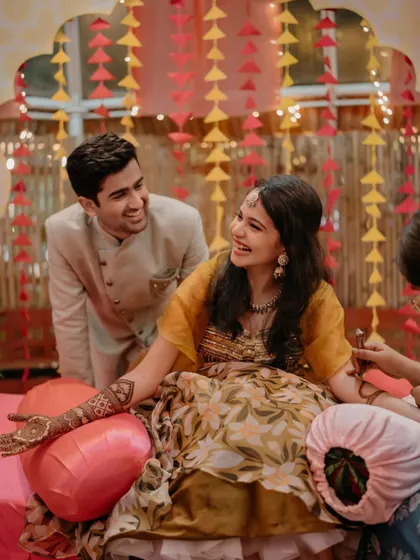 A sweet, candid moment as the groom admires the bride's mehndi during their ceremony.