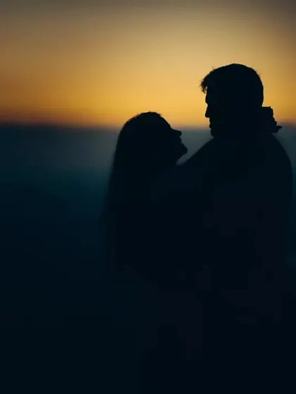 A dramatic silhouette of a couple against the setting sun, capturing a moment of pure romance.