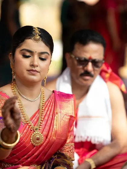 A candid shot of the bride during her wedding rituals. The makeup is designed to look perfect from every angle, even in unposed moments.